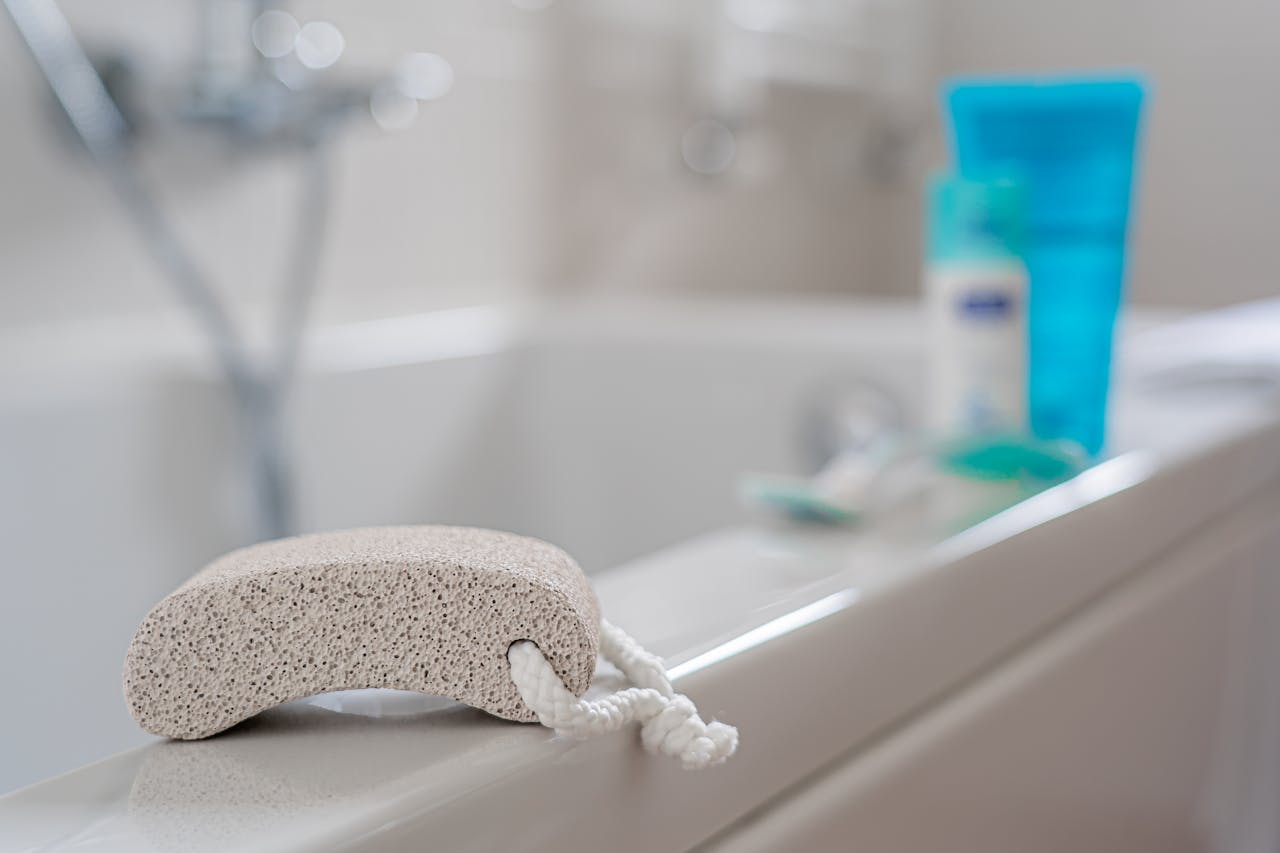 A pumice stone placed on a bathtub edge, ideal for foot care in a contemporary bathroom setting.